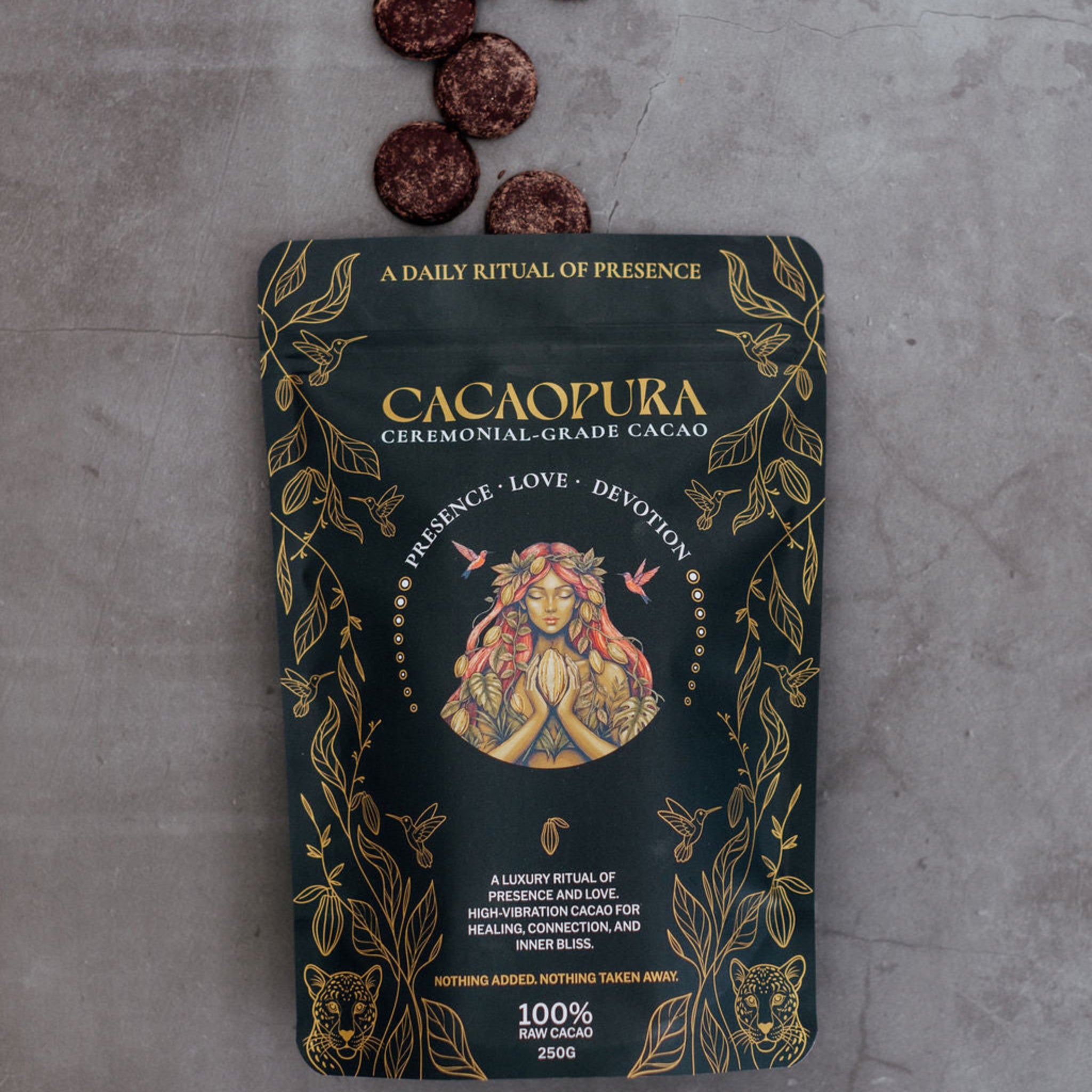 Cacaopura ceremonial-grade cacao package with cacao coins on a gray surface